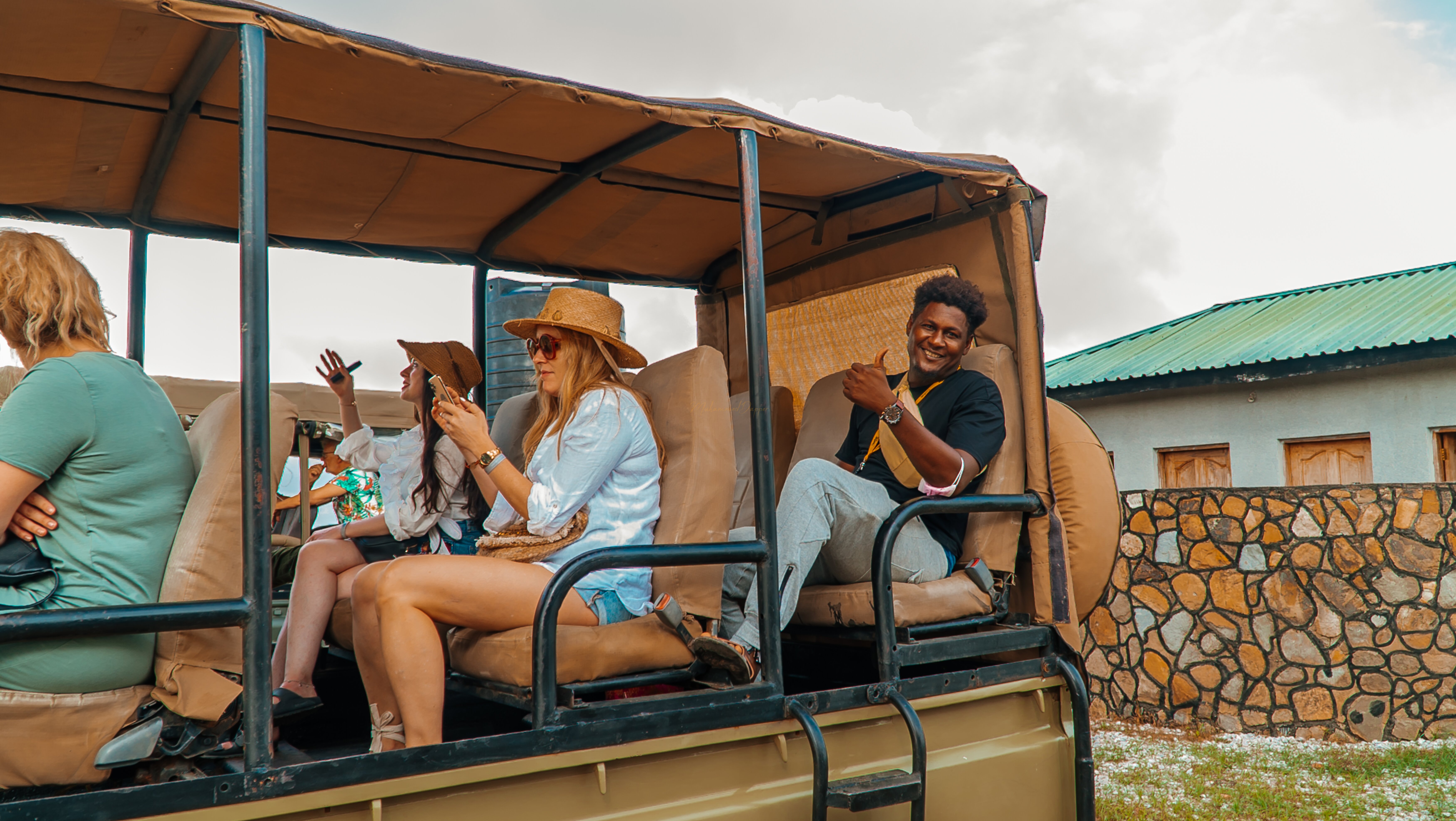 Guests and a smiling guide in an open safari vehicle in Mikumi National Park